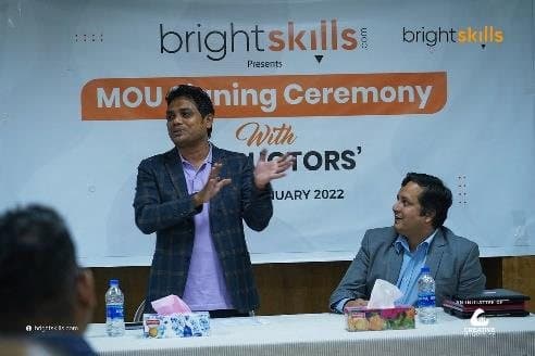 Anower Sadath Kabir seated at a table during a Bright Skills MoU signing ceremony with instructors